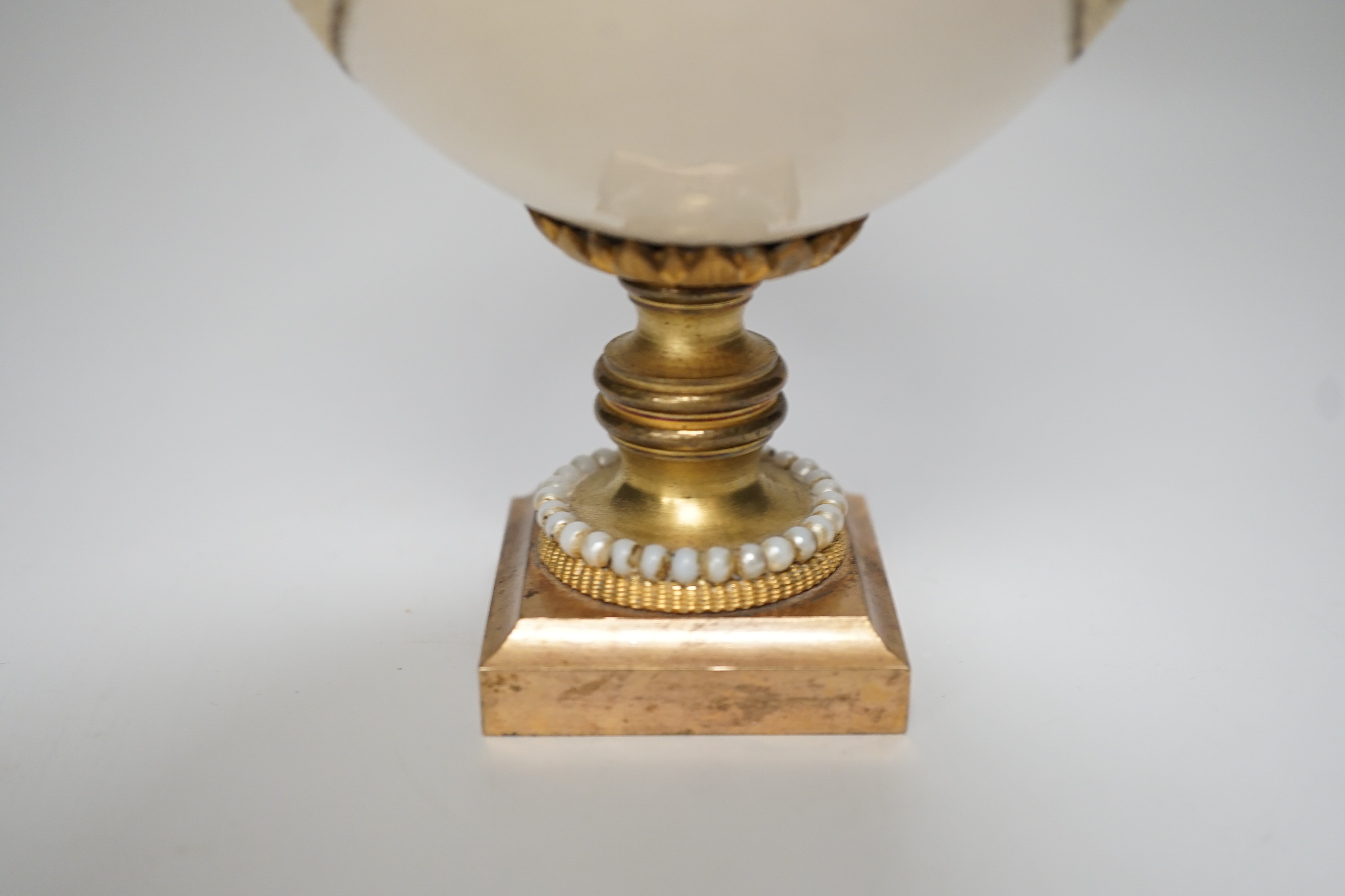 A decorated ostrich egg on gilt stand with a gilt and seed finial, 27cms high